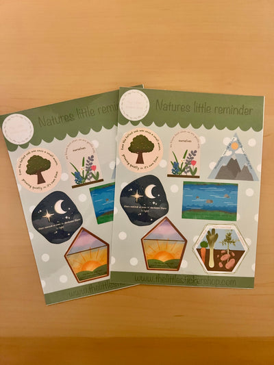 Two sheets of nature-themed stickers with illustrations on a wooden surface.