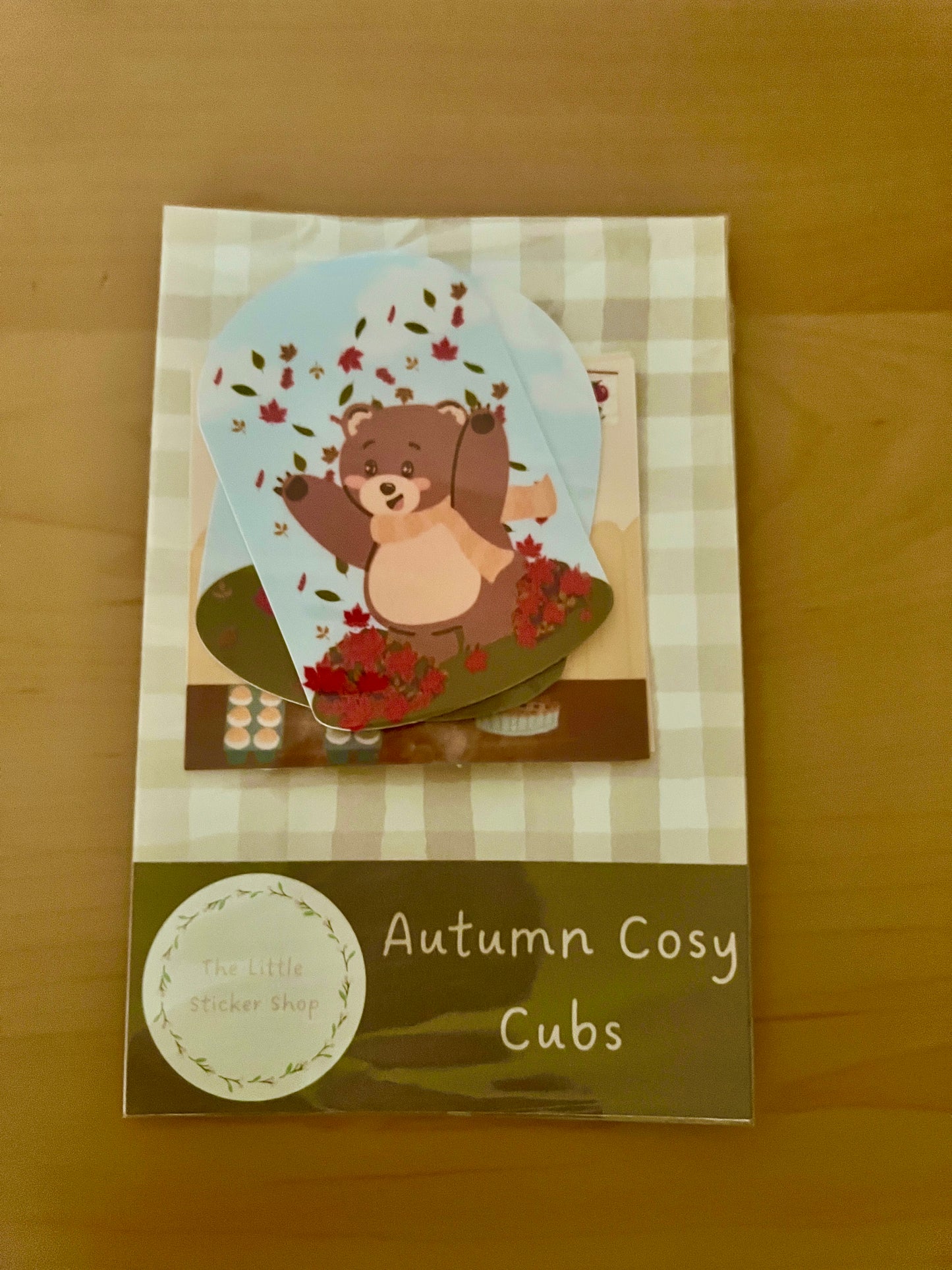Packaging of 'Autumn Cosy Cubs' with a bear illustration on a checkered background