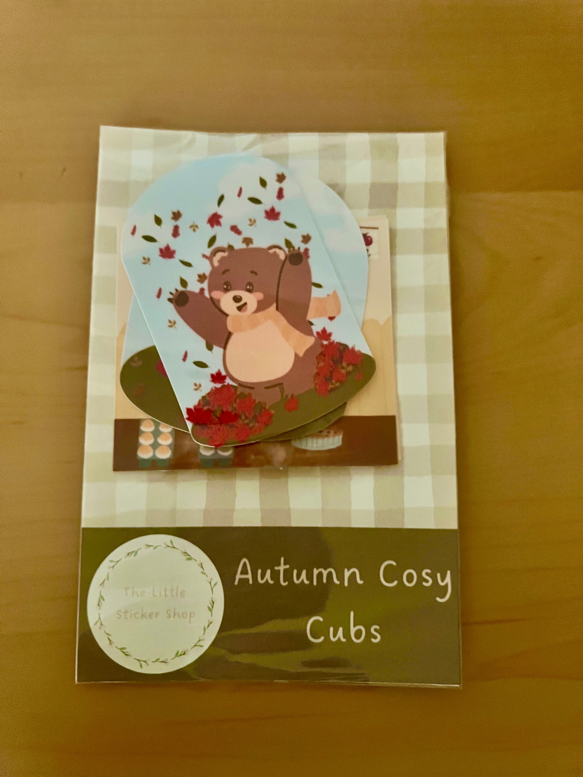 Packaging of 'Autumn Cosy Cubs' with a bear illustration on a checkered background