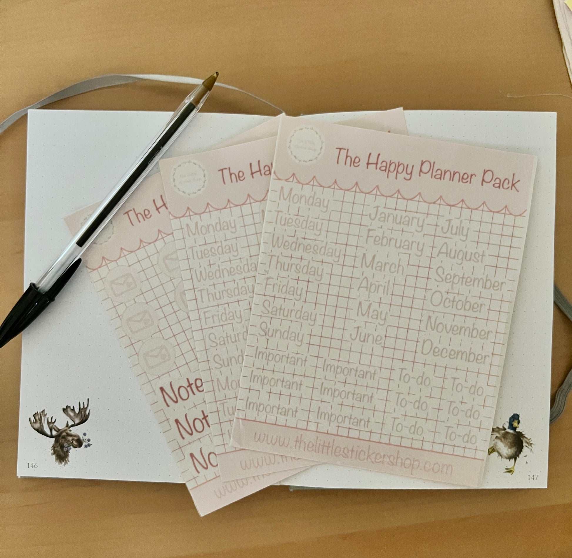 Happy Planner Pack sticker sheets pack of 3, displayed on a notebook on a wooden surface
