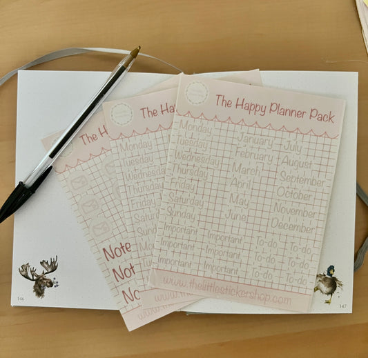 Happy Planner Pack sticker sheets pack of 3, displayed on a notebook on a wooden surface