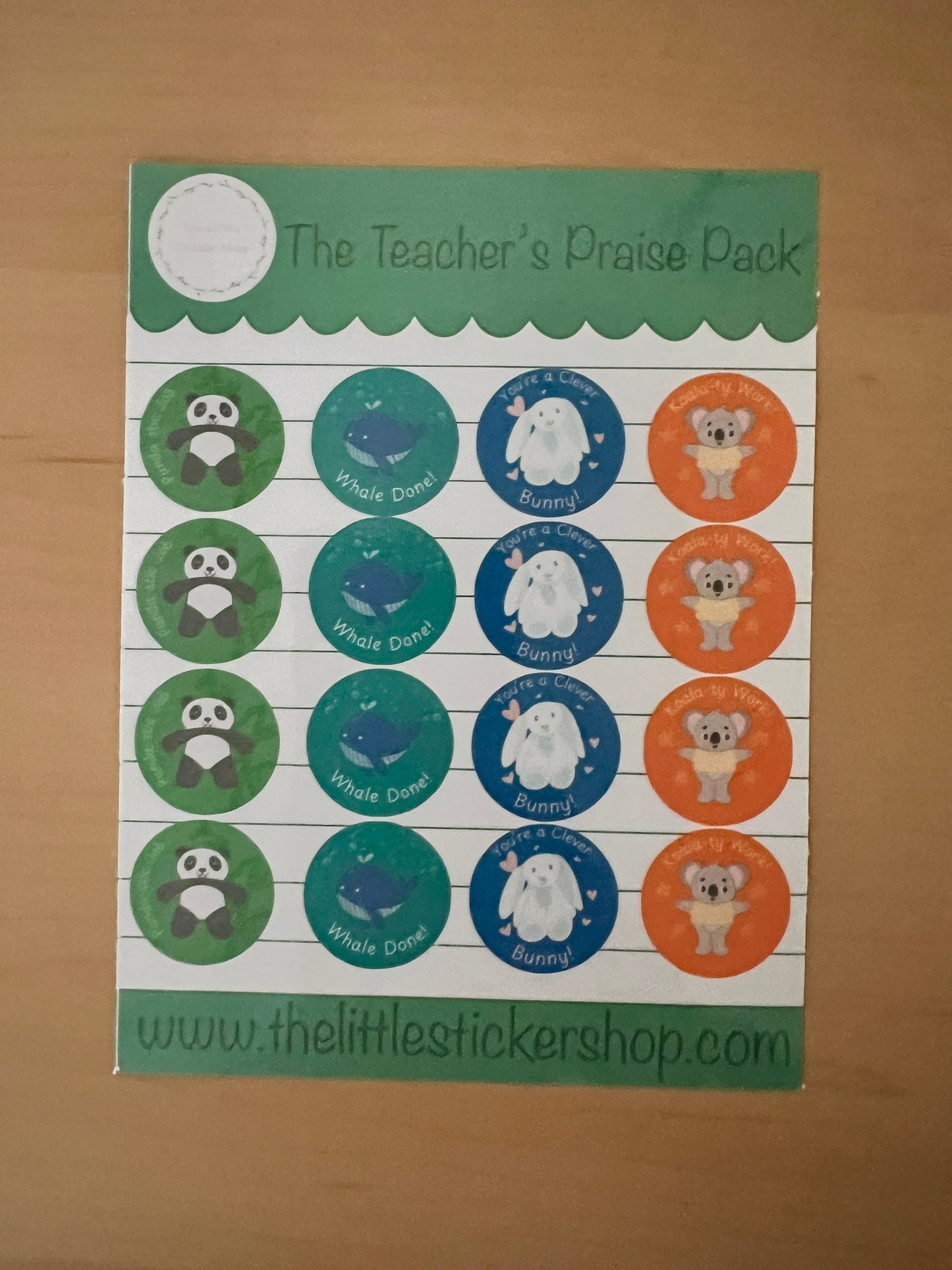 Sheet of stickers with various designs of cute animals with praise phrases on a wooden surface