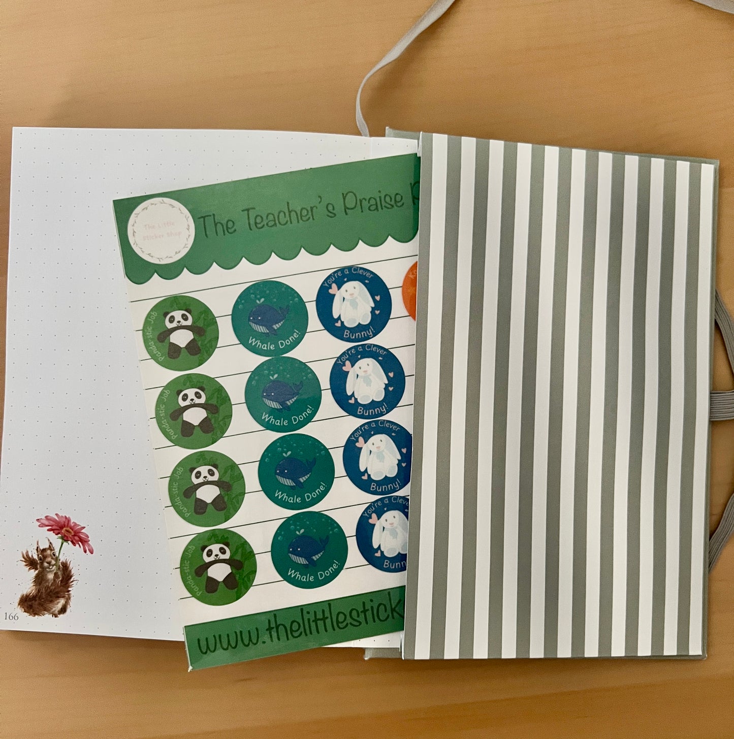 Sheet of stickers with animal illustrations with punny praise phrases on a wooden surface