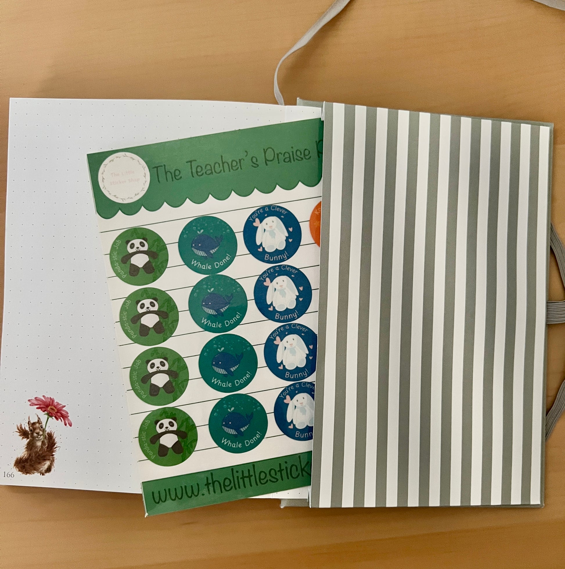 Sheet of stickers with animal illustrations with punny praise phrases on a wooden surface